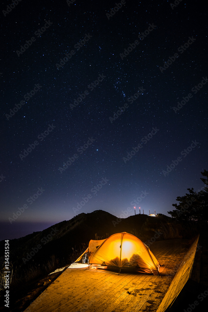 The camping with stars on the top of the mountain.