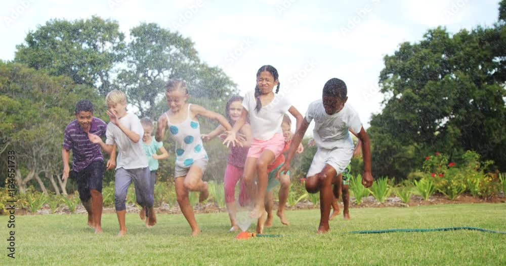 Kids playing with garden sprinkler in garden on a sunny day 4k Kids playing with garden sprinkler in garden on a sunny day 4k