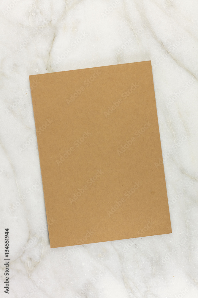 Brown kraft card on white marble texture Brown kraft card on white marble texture