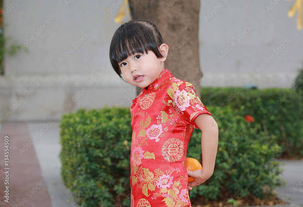 Cute asian kid girl in Traditional Chinese dress with holding sacred Orange at chinese temple in bangkok thailand, Chinese new year concept. Cute asian kid girl in Traditional Chinese dress with holding sacred Orange at chinese temple in bangkok thailand, Chinese new year concept.