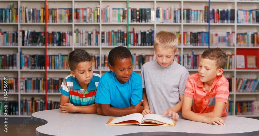 School kids reading book together in library at elementary school 4k ...