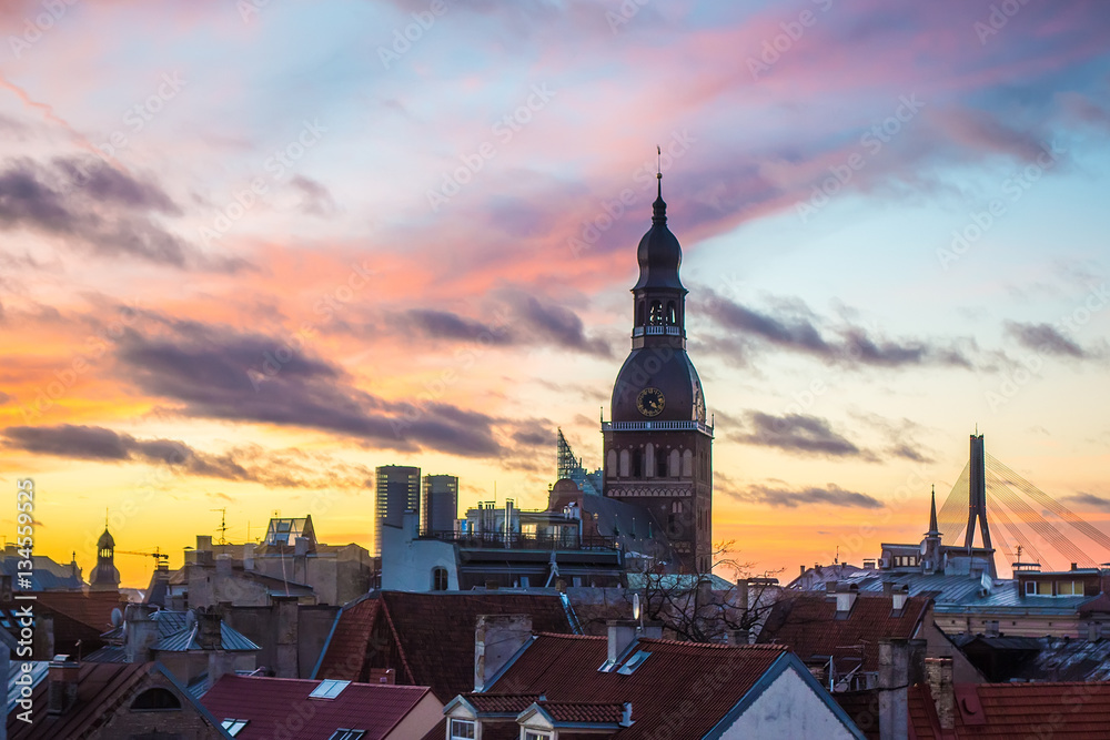 Old Riga roofs and Saint Peters Church on sunset