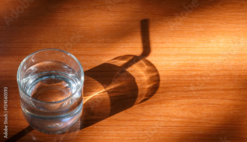 Glass of water on with light and shadow.