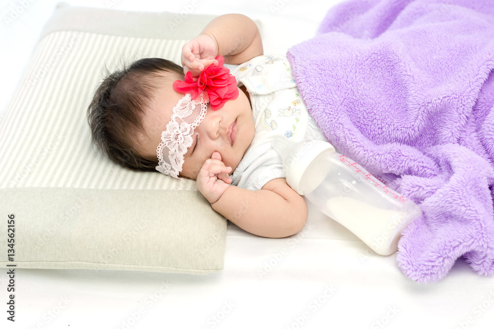 Portrait of adorable baby girl lying on the bed with milk bottle Portrait of adorable baby girl lying on the bed with milk bottle