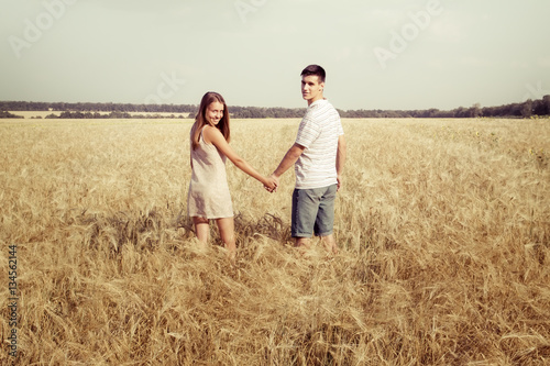 love couple walking in field holding hands