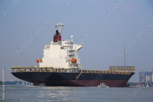 Container ship Going into the harbor And a customs ship to sail either side to go up on items on board.