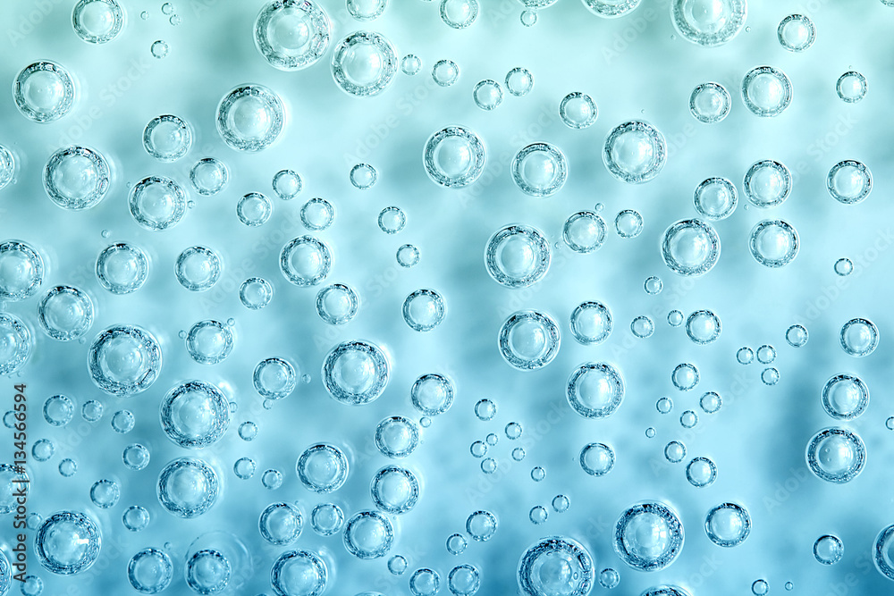 Macro Carbon dioxide (CO2) bubbles in water on a blue background, ecology concept