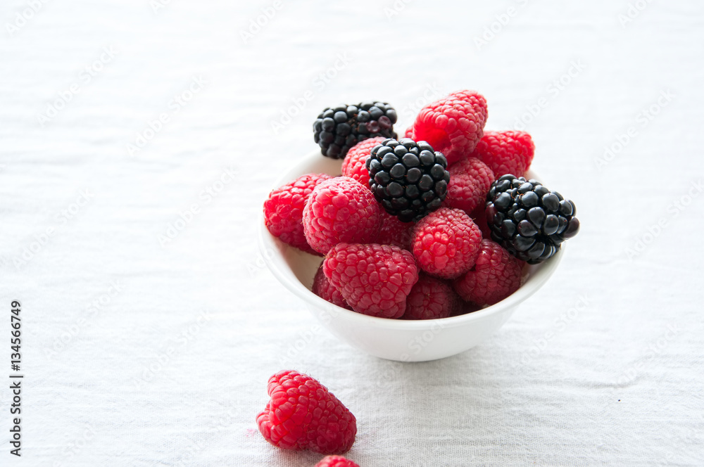 Fresh raw berries in a white bowl on a table Fresh raw berries in a white bowl on a table