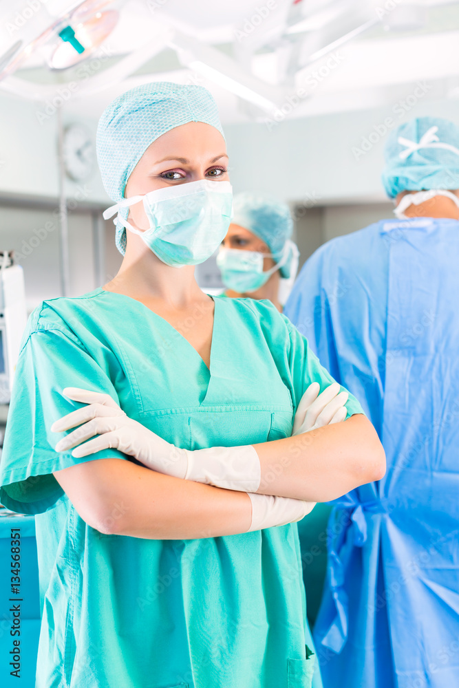 Krankenhaus - Junge Ärztin oder Chirurgin steht in einem sterilem OP-Saal oder Reinraum einer Klinik Krankenhaus - Junge Ärztin oder Chirurgin steht in einem sterilem OP-Saal oder Reinraum einer Klinik
