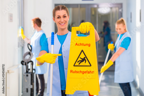 Putzfrau zeigt Warnschild  photo