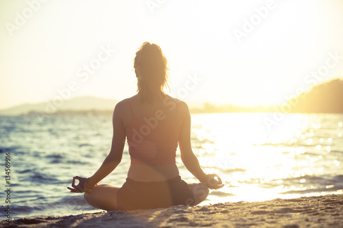 Young woman practicing yoga on the beach. © s4svisuals