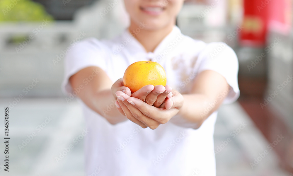 asian woman in White traditional chinese dress with holding sacred Orange at chinese temple in bangkok thailand, Chinese new year concept. asian woman in White traditional chinese dress with holding sacred Orange at chinese temple in bangkok thailand, Chinese new year concept.