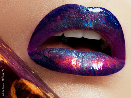 Closeup of beautiful full woman's lips with bright fashion gloss makeup. Macro shot with magenta lip make up. Beautiful lips with pink pigment. Beauty and fashion concept