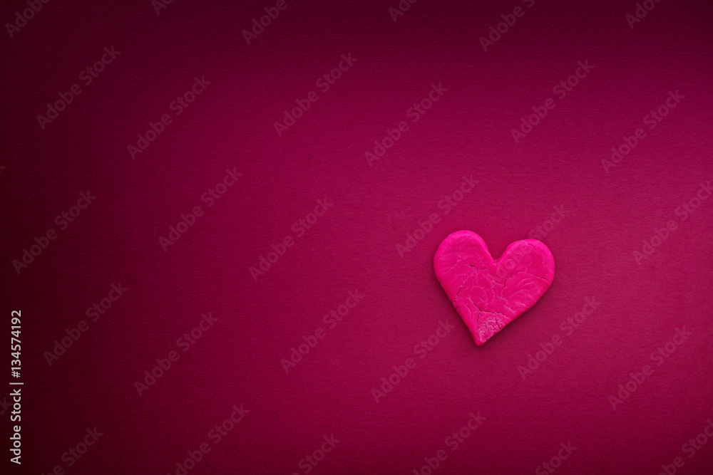 Red heart with small cracks on hot pink background