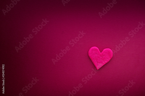 Red heart with small cracks on hot pink background
