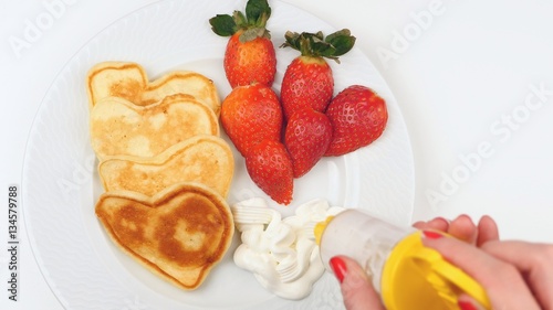 Fototapeta Naklejka Na Ścianę i Meble -  Heart-shaped pancakes with strawberry on a white dish.