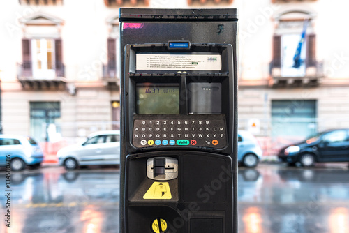 Parcometro in una strada di città, funzionante con denaro contante e con carte di credito.