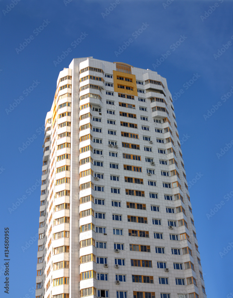 Front view of high new constructed residential building over clear blue sky vertical view
