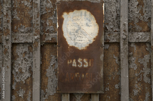 Vecchio cancello con cartello arruginito