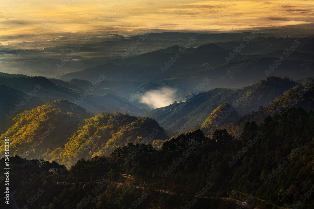 Landscape in Doi Ang Khang Chiang Mai Thailand with misty morning sunrise over mountains.