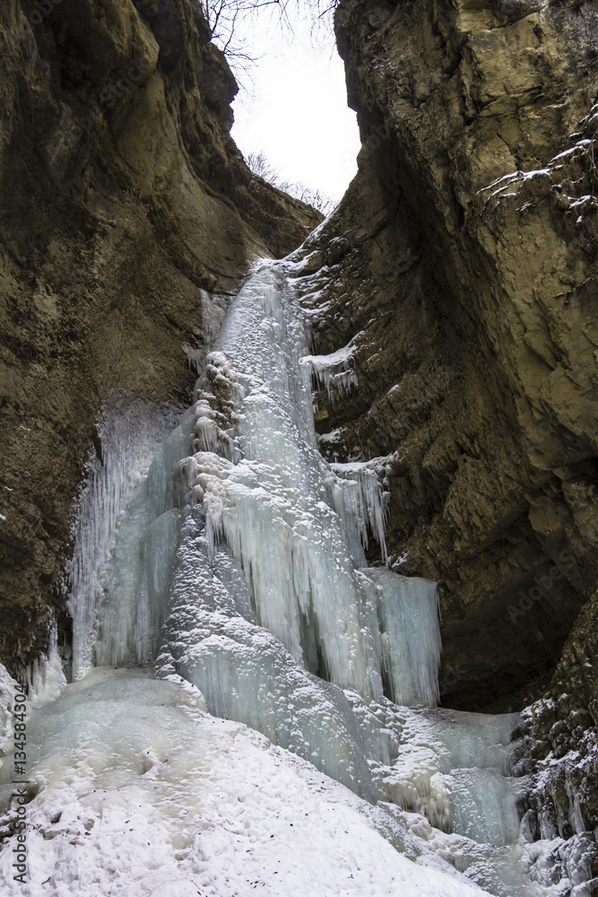 замерзший водопад между горными скалами, зимний пейзаж