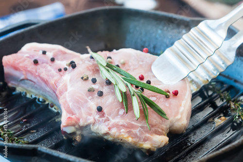 Grill meat on bone with rosemary, thyme, pepper and garlic photo