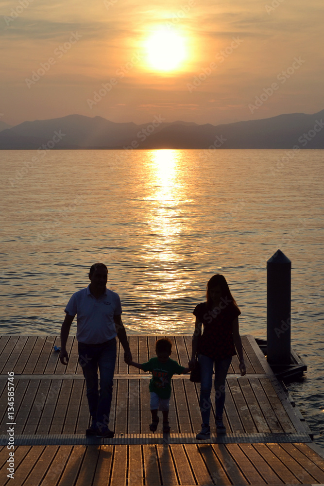 Fototapeta premium famiglia felice sul pontile del lago di garda