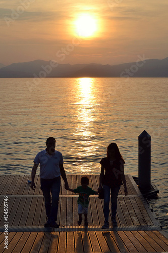 famiglia felice sul pontile del lago di garda © sara