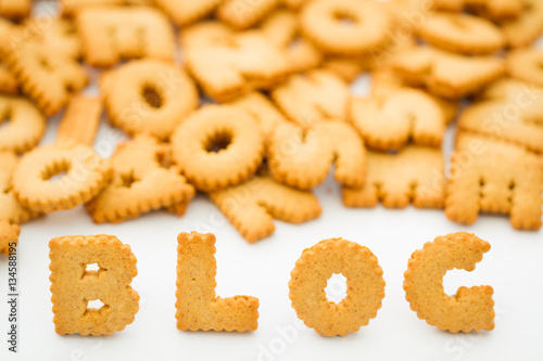 The word blog created from alphabet shaped cookies or biscuits on an isolated white background for a food blogger.