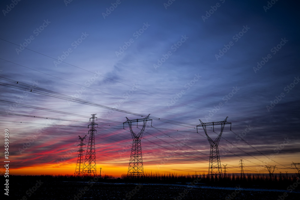 The silhouette of the evening electricity transmission pylon