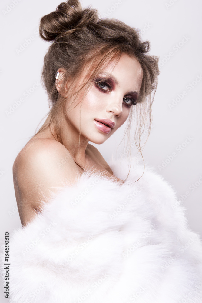 Beautifful european brunet woomen with gloss clean healfy skin, glooss shiny pastel pink lipstik and with trendy fashion hairstyle in white fluffy fur coat