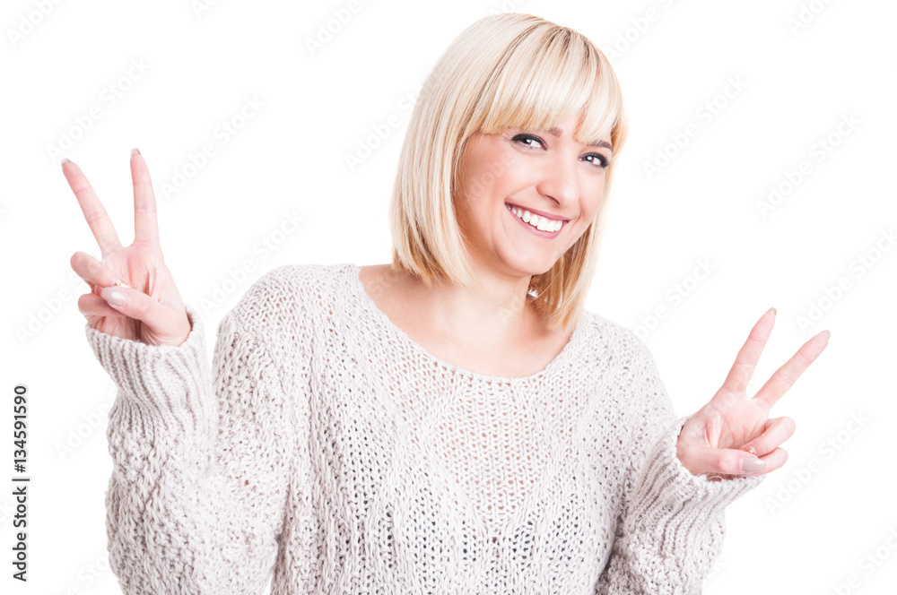 Pretty woman wearing warm sweter showing double peace