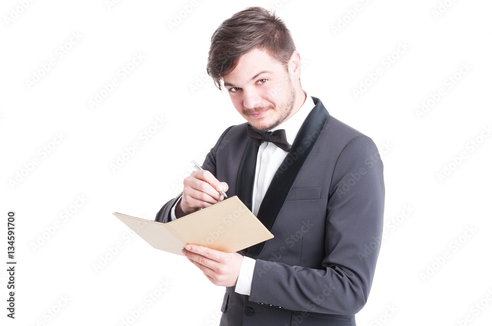 Handsome man wearing tuxedo and bowtie writing on notebook Handsome man wearing tuxedo and bowtie writing on notebook