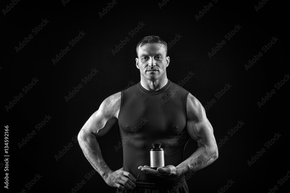 handsome sexy athlete man with muscular body holds steroid jar