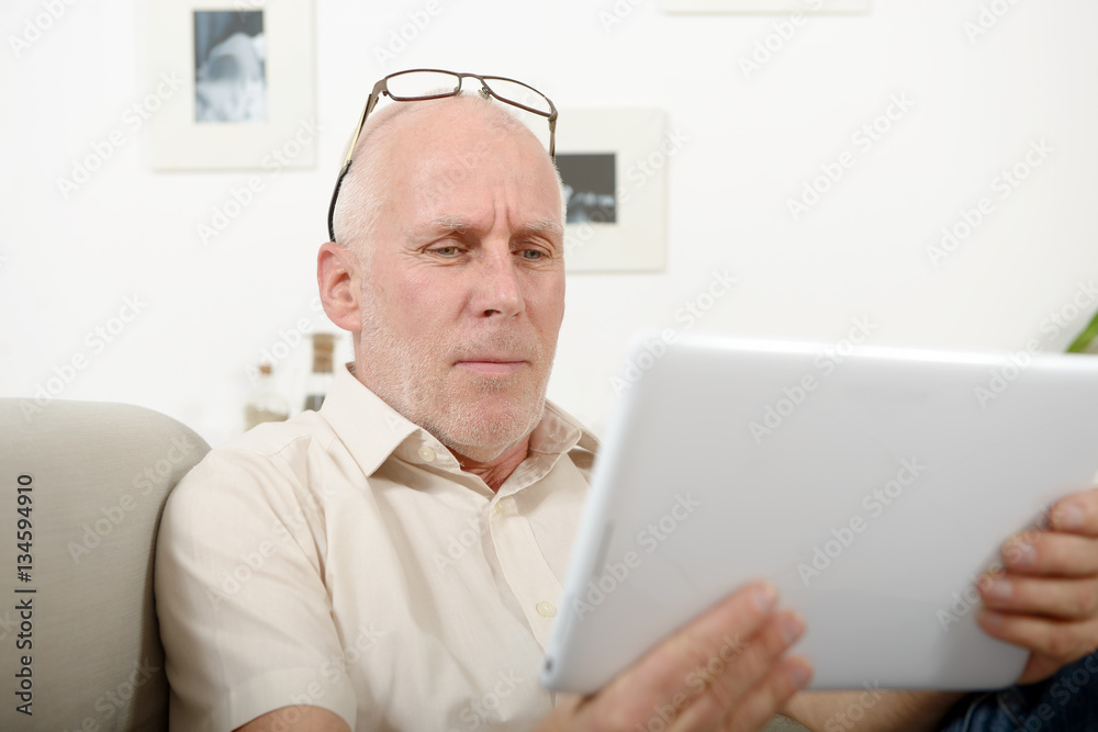 mature man having eyesight problems, he using tablet mature man having eyesight problems, he using tablet