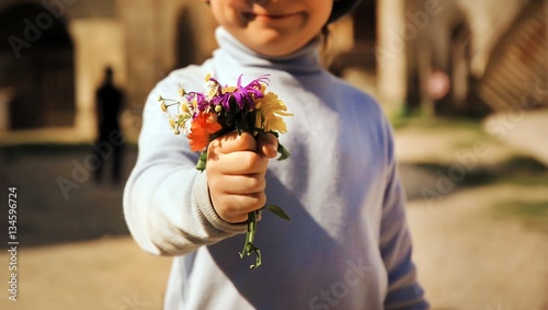 Boy with bouquet of wild flowers in a hand