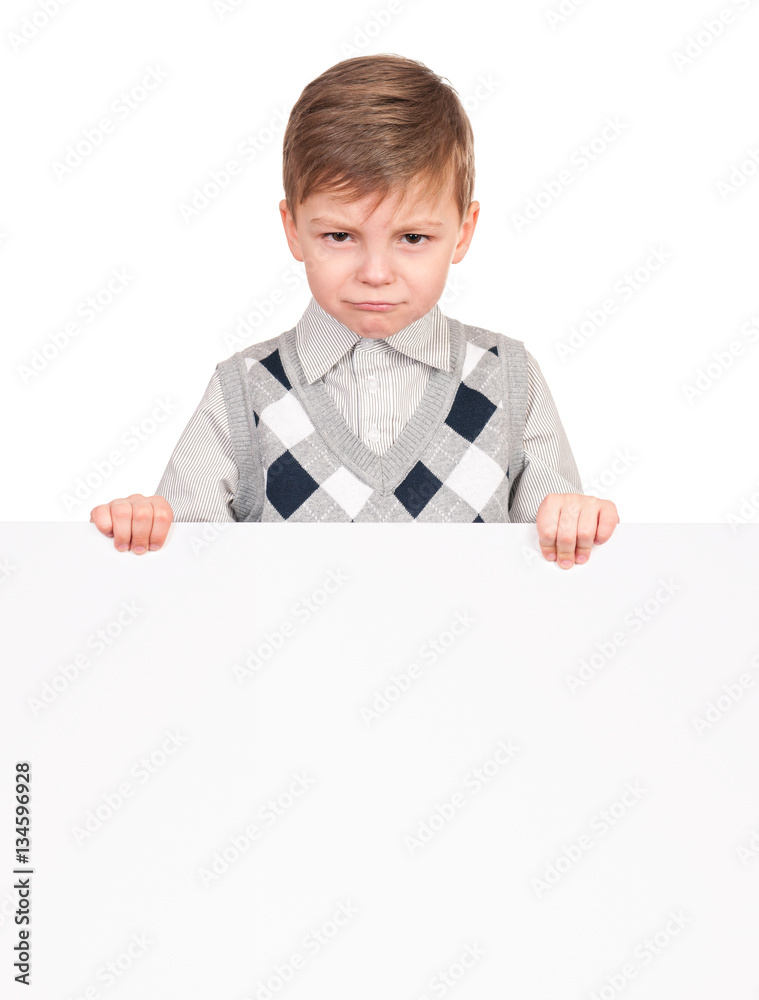 Portrait of a unhappy little boy with blank signboard, isolated on white  background. Sad child holding banner and looking at camera. Funny kid  peeking from behind empty panel or placard board. Stock