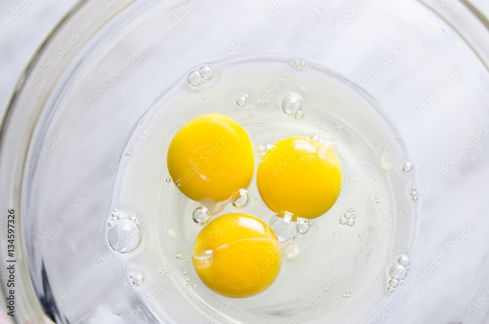 Beautiful picture of eggs in a white bowl with beaters near yolk Beautiful picture of eggs in a white bowl with beaters near yolk