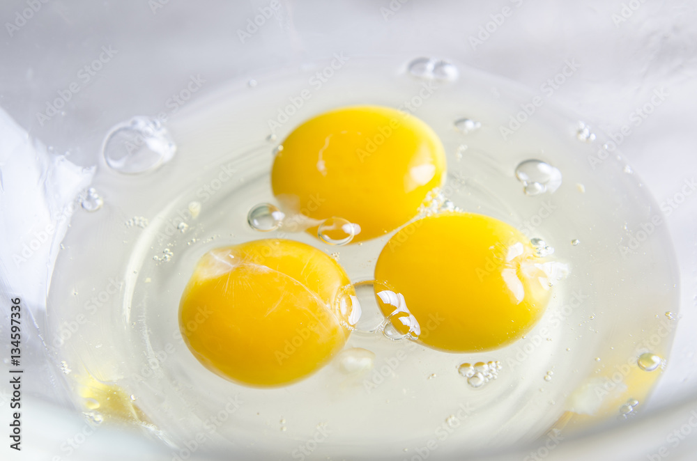 Beautiful picture of eggs in a white bowl with beaters near yolk Beautiful picture of eggs in a white bowl with beaters near yolk