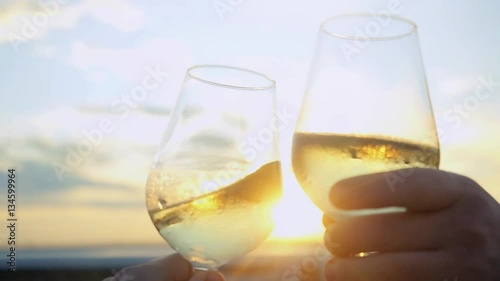 Businessmen toasting and drinking wine on the restaurant terrace over sunset in slowmotion with lense flare effects. Celebrating agreement. 1920x1080