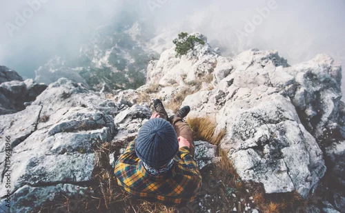 Obraz Podróżnika mężczyzna relaksuje samotnie na skalistej góry szczycie nad chmurami Podróżuje stylu życia sukcesu pojęcia przygody aktywnych wakacji plenerowego odgórnego widok