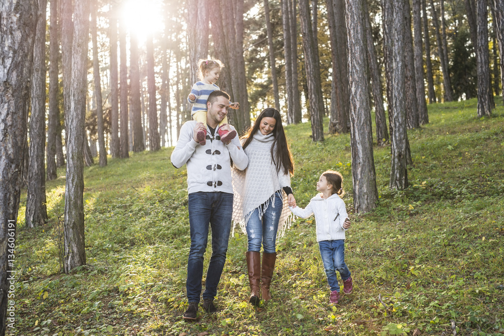Happy family with two girls walking in forest Happy family with two girls walking in forest