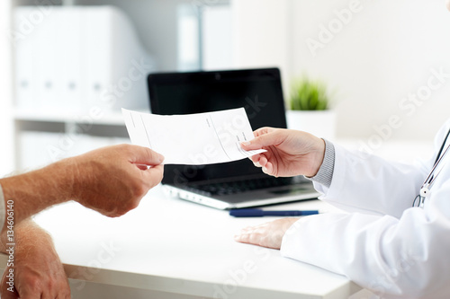 doctor giving prescription to patient at hospital