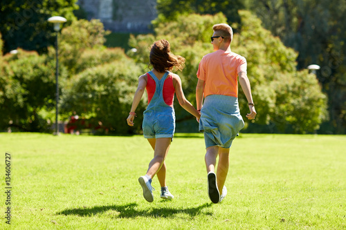 happy teenage couple walking at summer park
