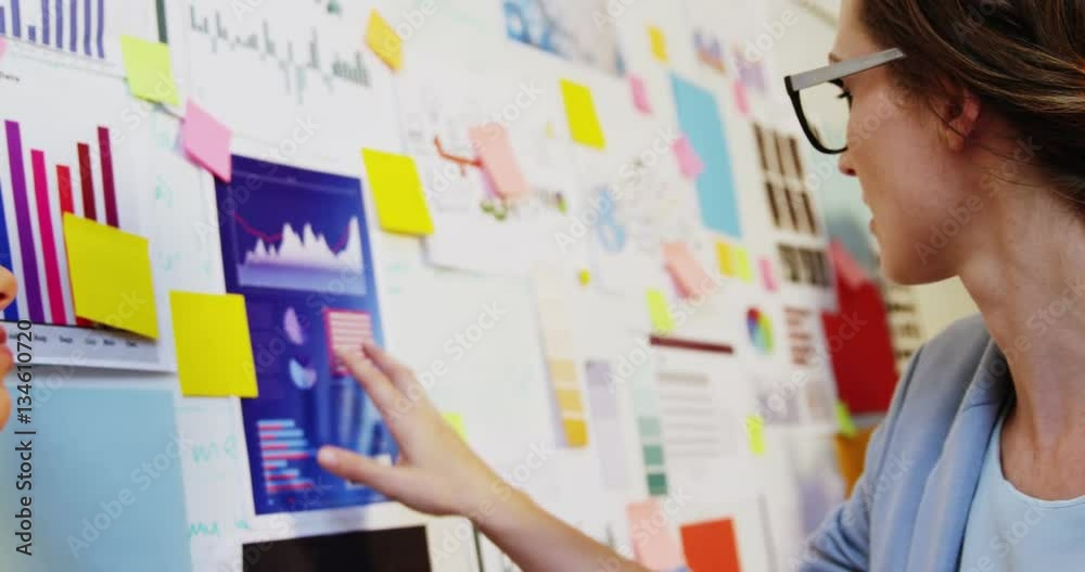 Businesswoman looking at sticky notes on whiteboard in office 4k Businesswoman looking at sticky notes on whiteboard in office 4k