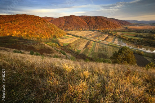 Autumn sunset. Fall landscape with hills, grass and vivid colors