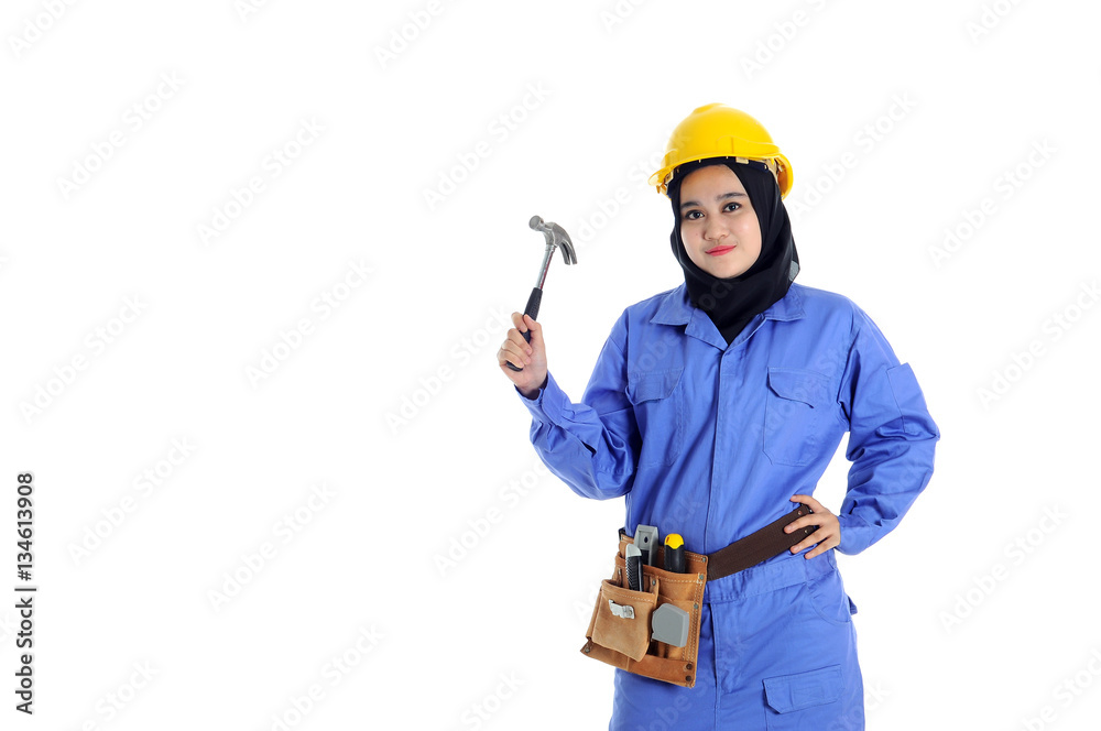 Construction worker wear yellow safety helmet in action while holding a hammer Construction worker wear yellow safety helmet in action while holding a hammer