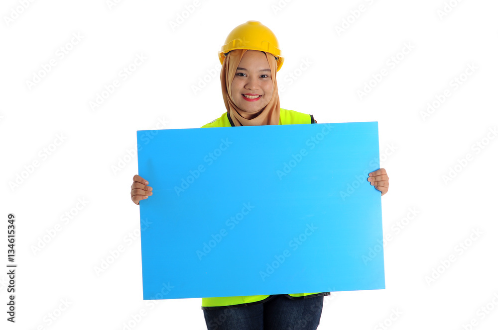 Construction worker wear yellow safety helmet look front and smile while holding text space card. Construction worker wear yellow safety helmet look front and smile while holding text space card.