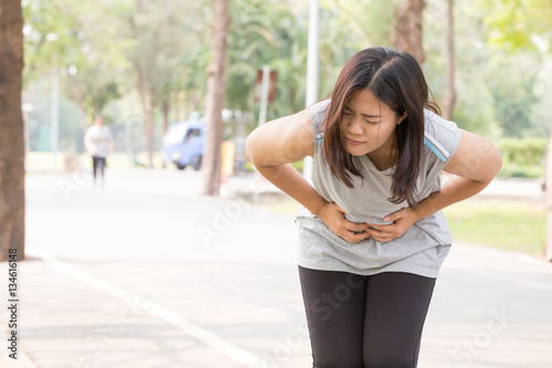 Asian woman stomachache while running in park © comzeal