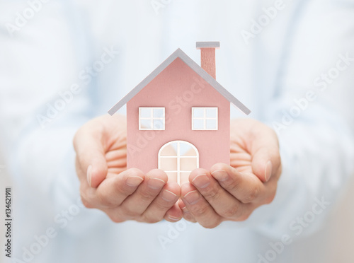 Small toy house in hands